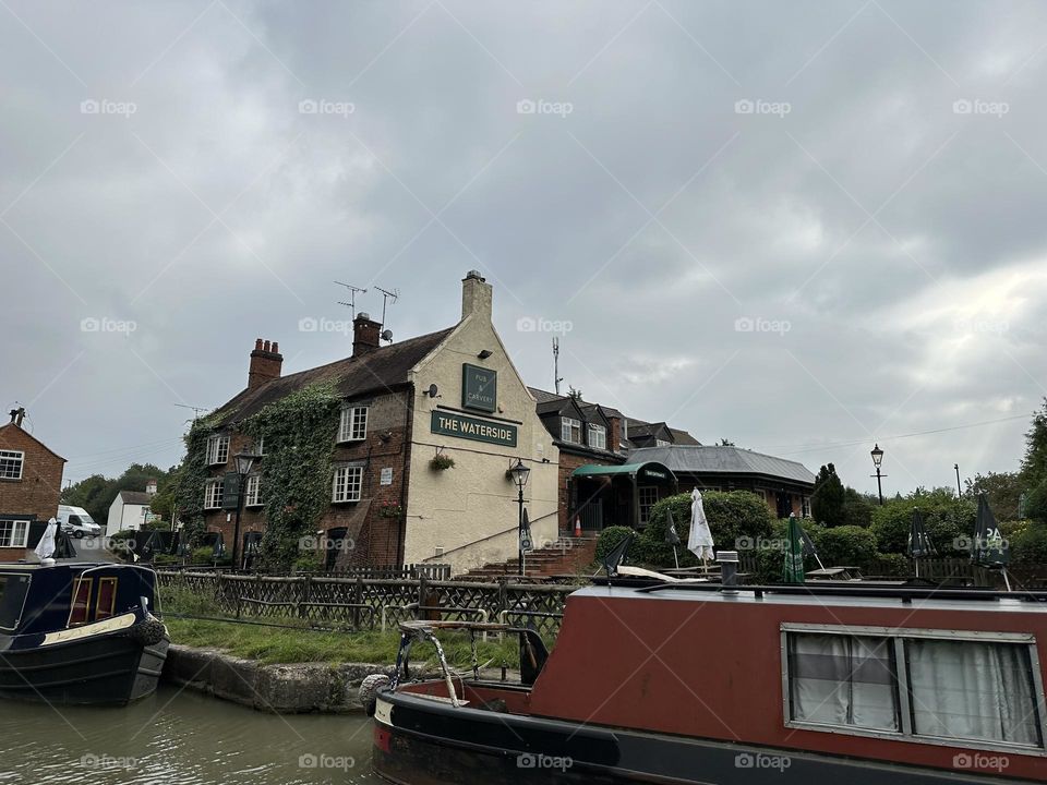 Canal view of The Waterside Pub and Carvery from narrowboat traveling on the Oxford canal near Rugby England