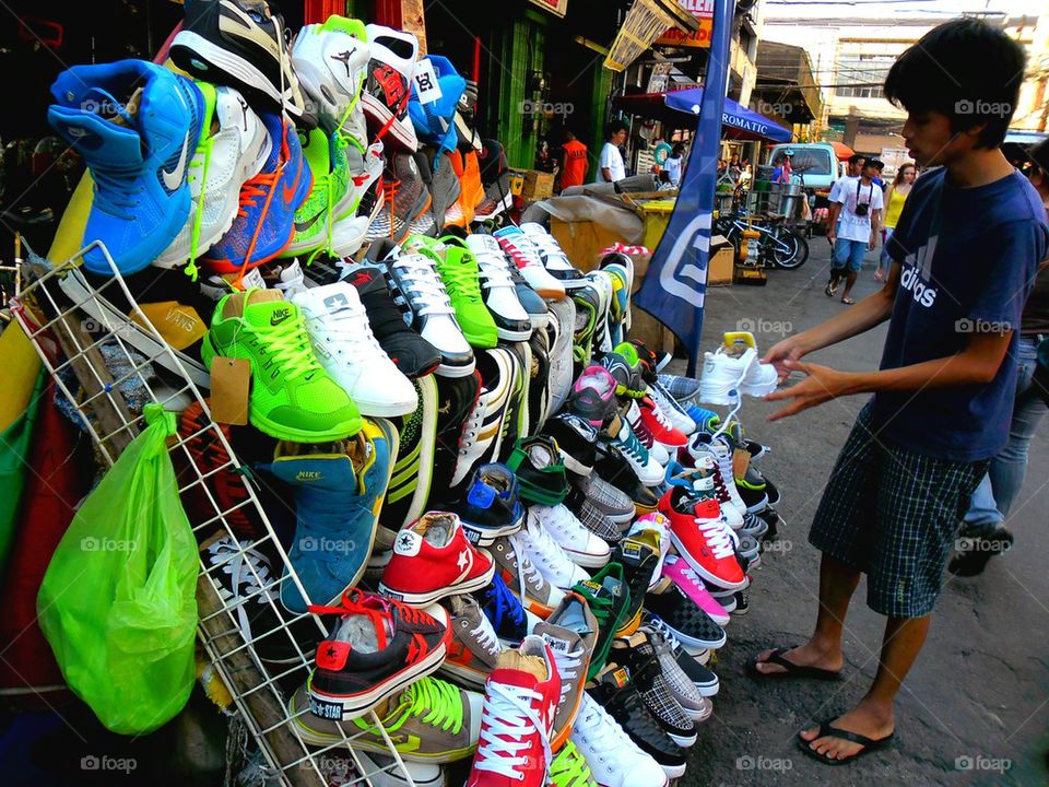 asian street vendor selling rubber shoes in quiapo, manila, philippines in asia