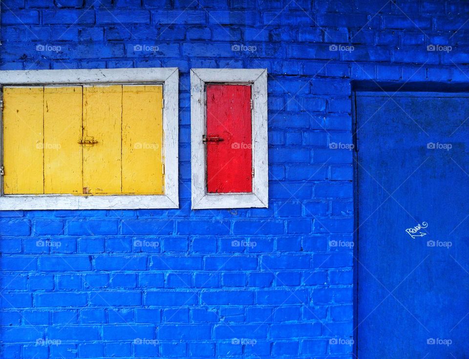 blue wall with yellow and red window