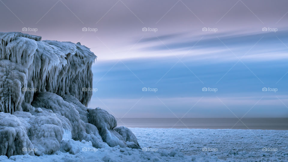 Frozen Cliff of Ice-cycles on a ice covered beach 