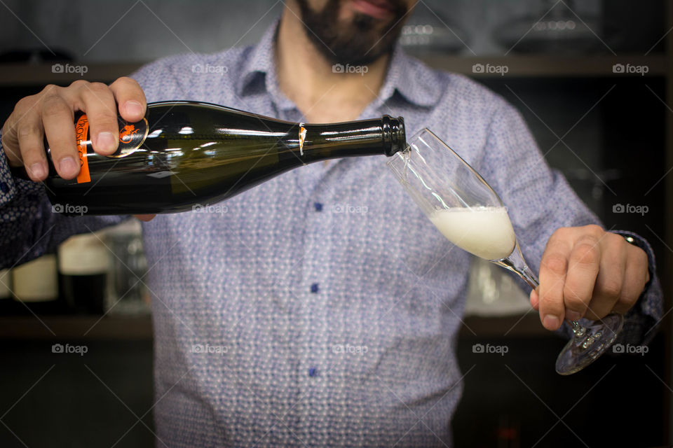 A man is preparing cocktail with sparkling wine and juice