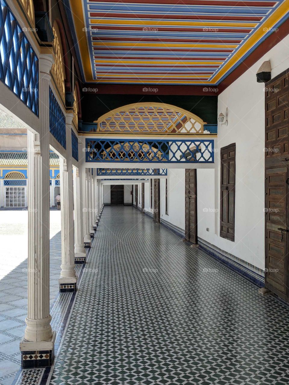 Colorful Hallway in the Shadows in the Courtyard of the Bahia Palace in Marrakech in Morocco - Striped Ceiling, Tiled Ceramic Mosaic Floors, Columns, and More