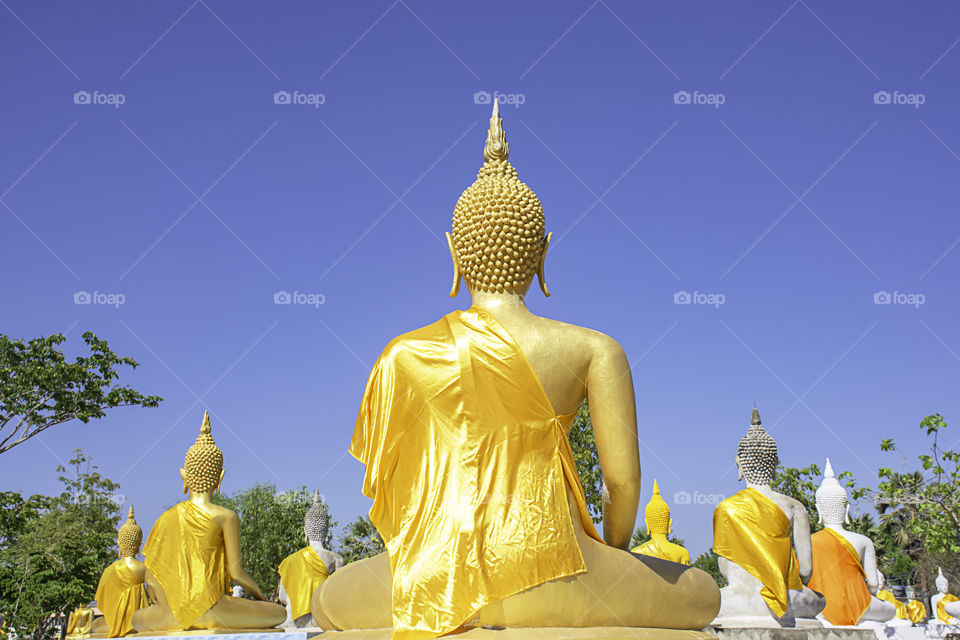 Behind the statue of Buddha  covered in yellow cloth Background sky at Wat Phai Rong Wua , Suphan Buri in Thailand.