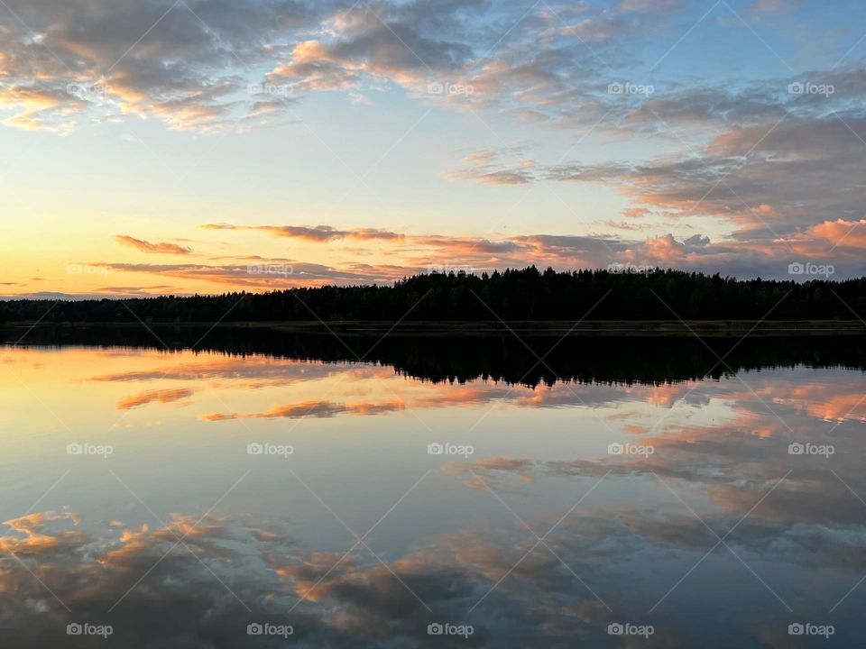 Beautiful tranquil sunset landscape over the mirror smooth sea water surface 