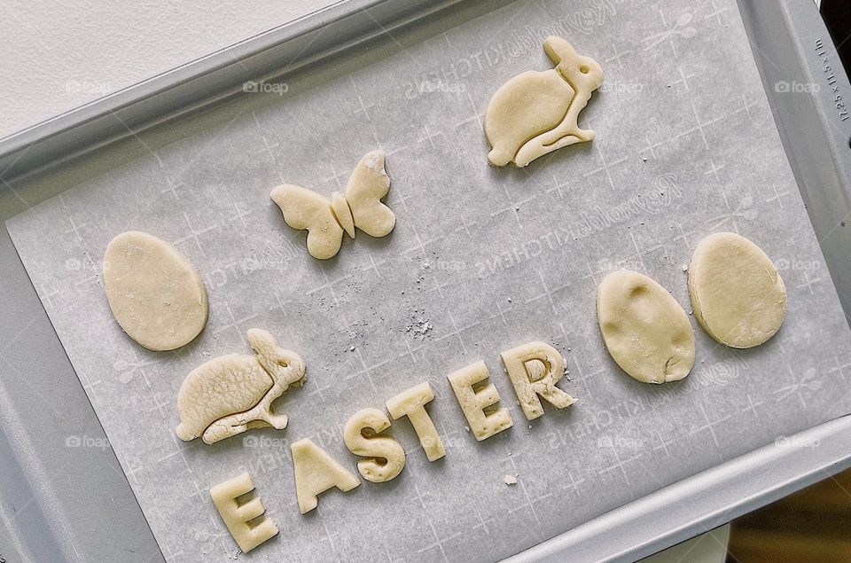 Making Easter sugar cookies with kids, cut out Easter sugar cookies on cookie sheet, getting ready to bake sugar cookies for Easter celebration, making homemade cookies with a toddler, cookies ready to go in the oven, cookies placed on a cookie sheet