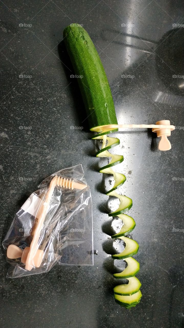 A simple tool to create vegetable spirals such as zucchini carrots potatoes and more. In this photo there is a zucchini that has been cut into a spiral. Good lunch.