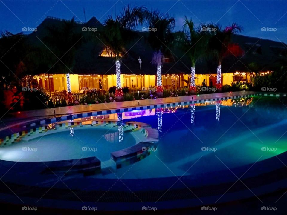 A night picture of a swimming pool and it's surrounding