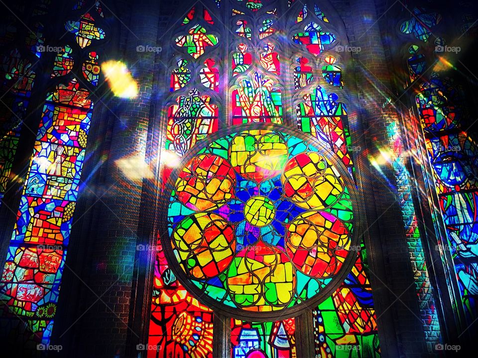 Sun beaming through a colorful stained glass window.