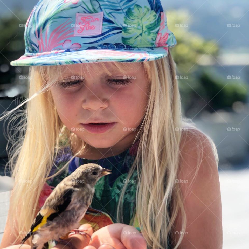 girl holding a bird in her arms