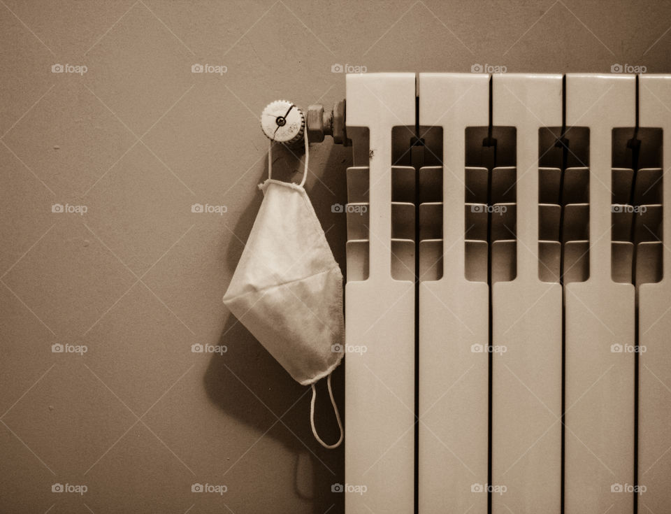 Face mask hanging on a heater.