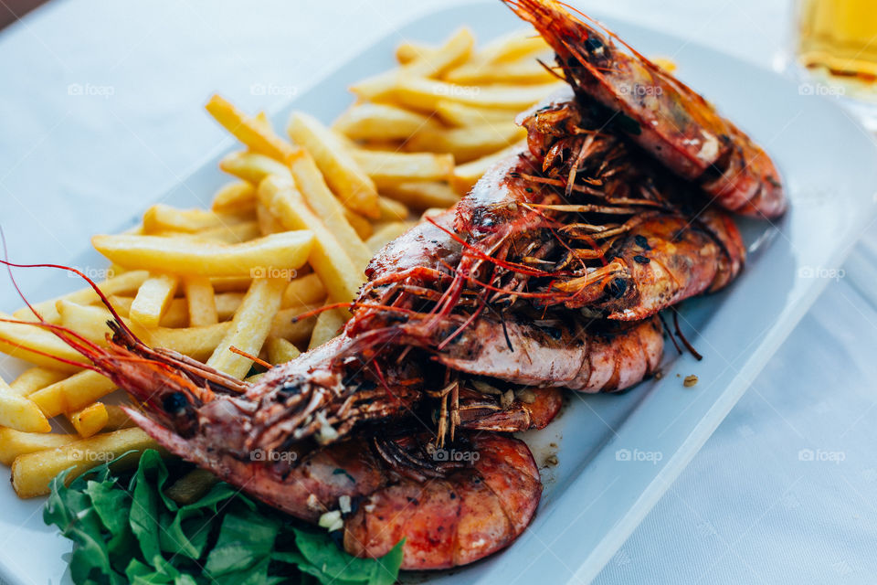grilled king shrimp on a plate of potatos