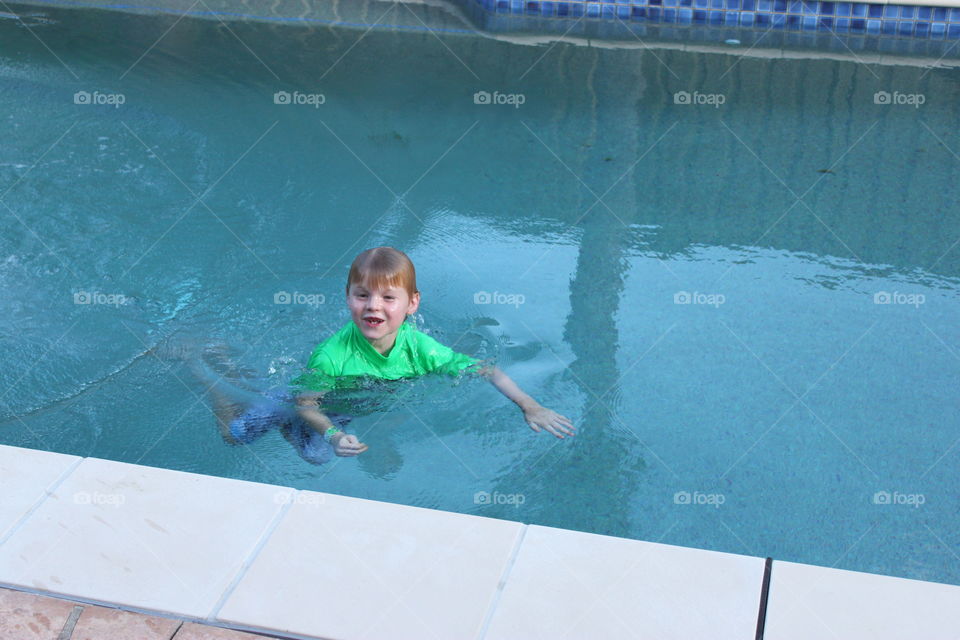 Happy boy swimming in pool