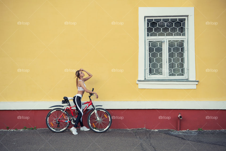 Beautiful girl on a red bicycle