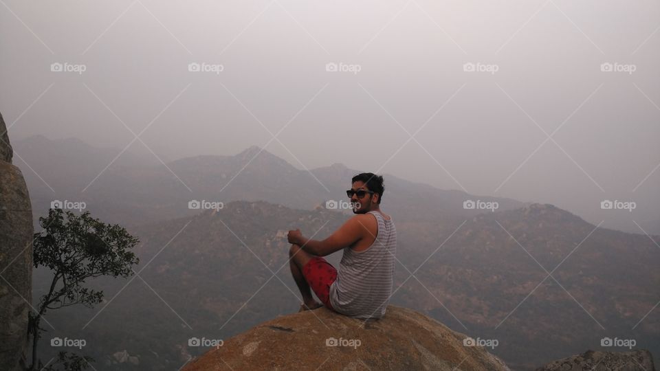 Man sitting on rock mountain