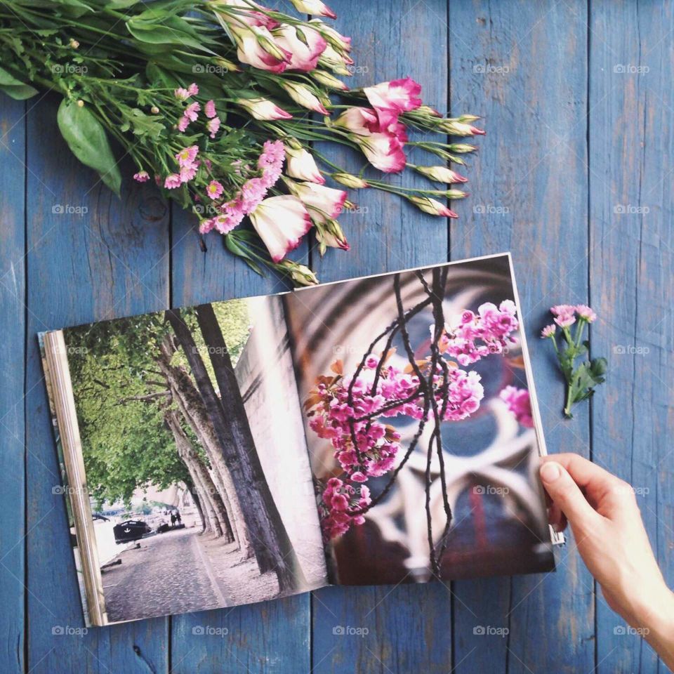 Book and flowers on the blue wooden table