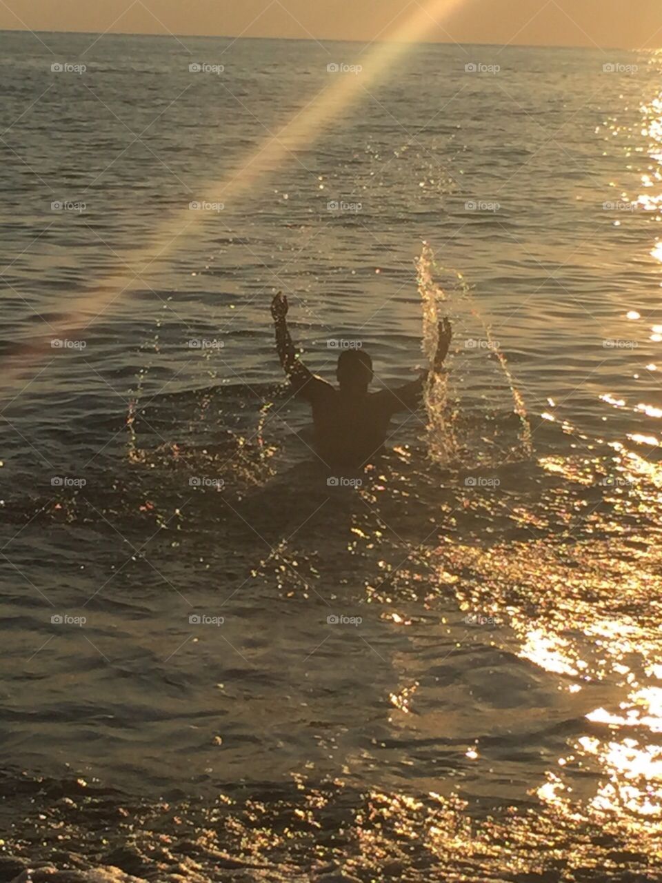 man in the sea and sunset