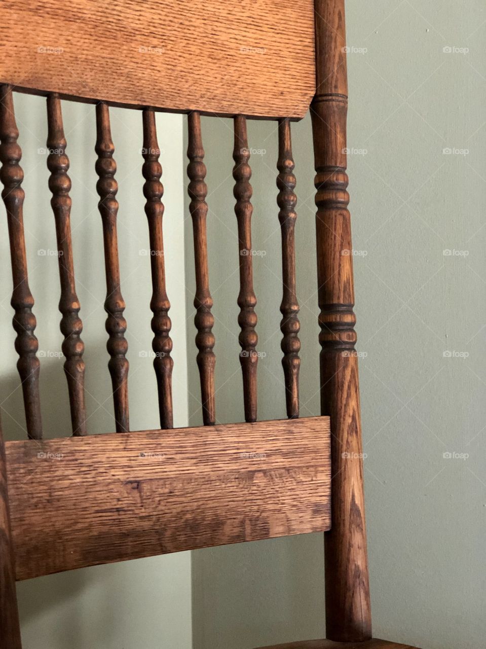 Closeup of antique wooden chair against blank wall 