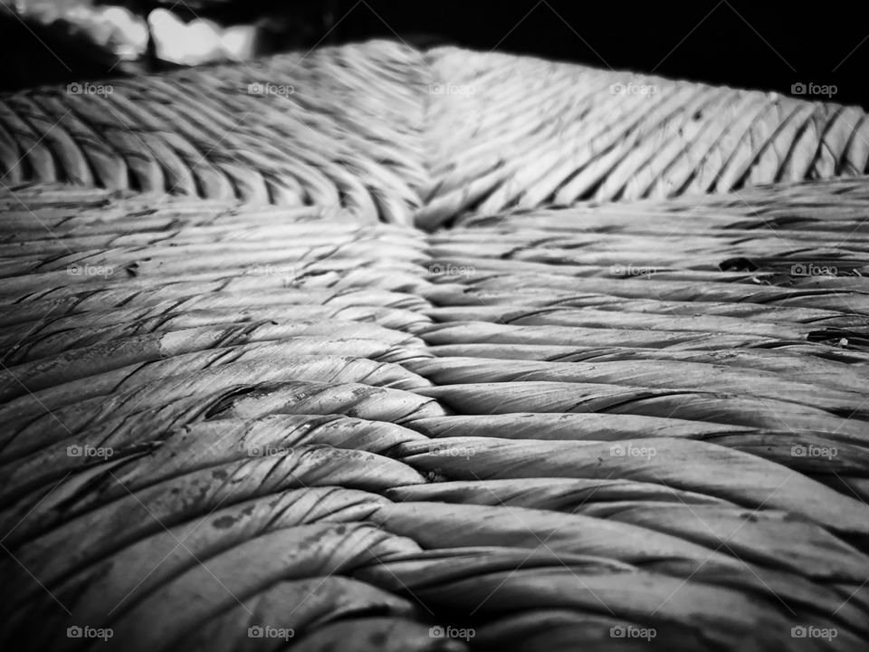 A B&W view of a straw seat, in a unique, close perspective, creating a beautiful abstract texture.