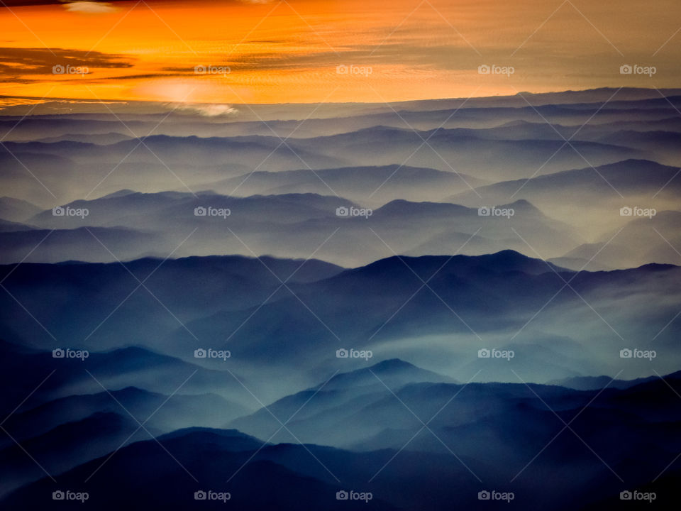 Sunset over in the Pacific Northwest mountains while smoke layers blanket the peaks. 