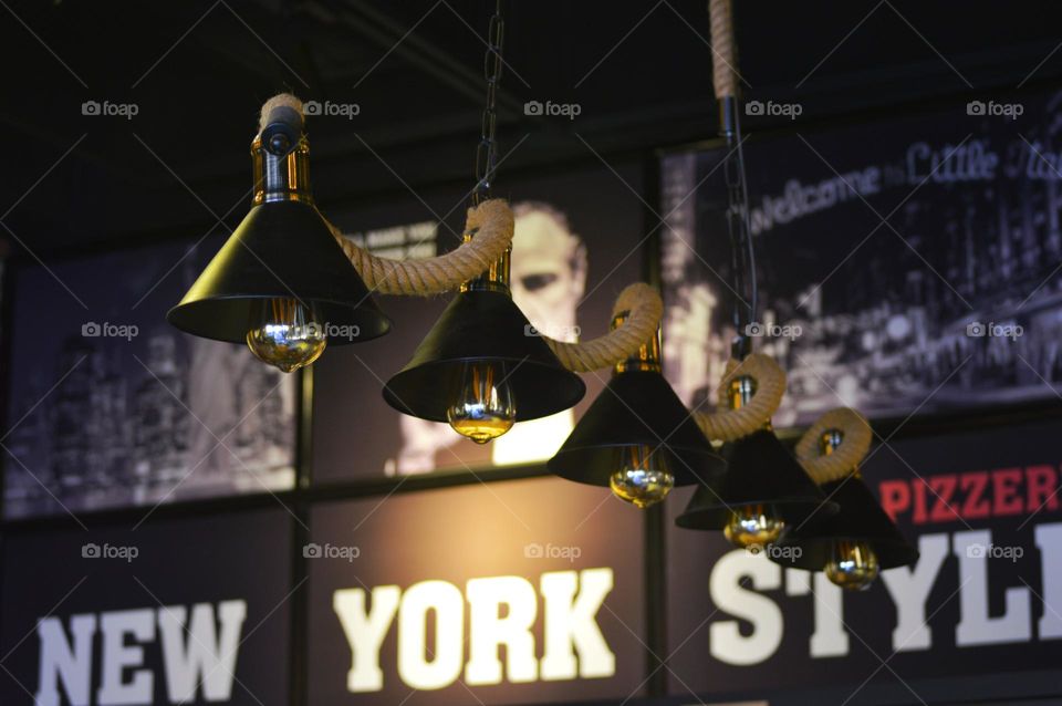 The cafe's stylized lighting consists of hanging martini lamps. graffiti on the walls of New York.