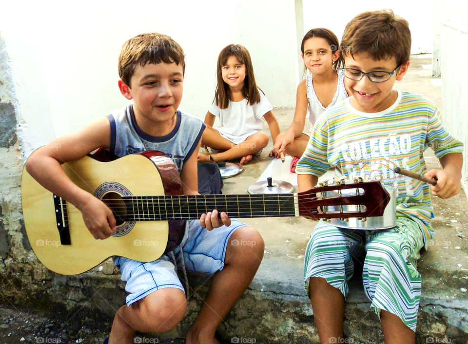 Group of children playing with guitar at outdoors