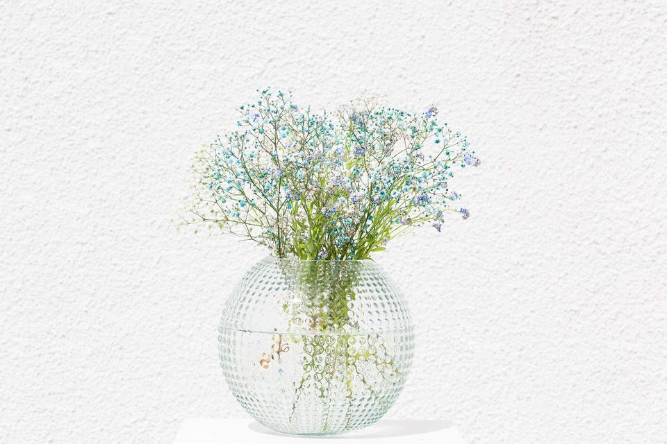 Big glass vase with blue summer flowers 
