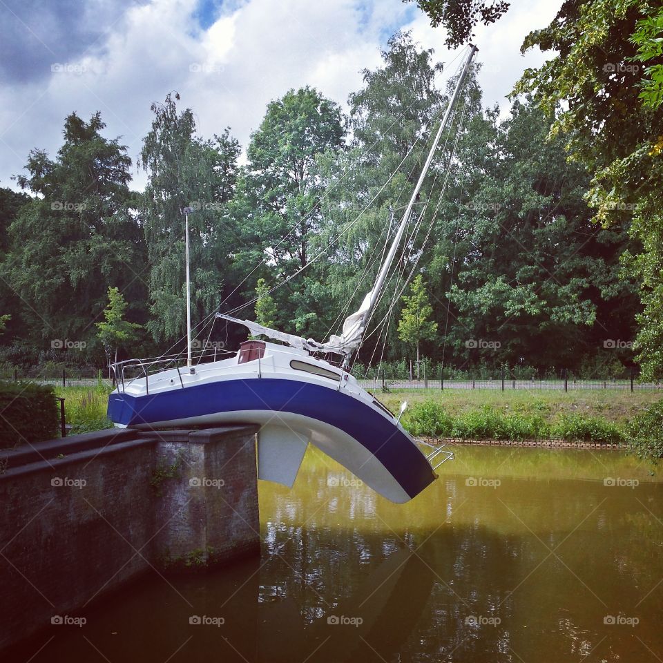 Boat bending to water. "Misconceivable" by Erwin Wurm as shown at the park of Middelheim