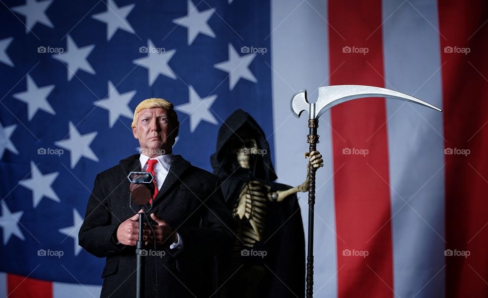 Donald trip with us flag and the grim reaper in the background 