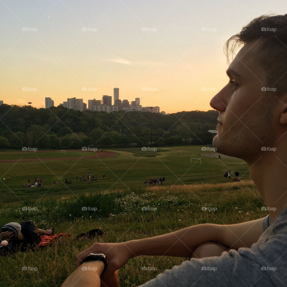 Man looking out over skyline at sunset. 