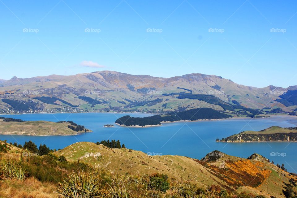 Scenic view of a sea with mountain against clear sky