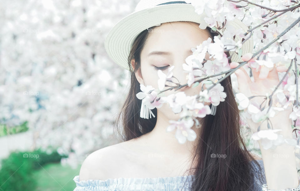 Close-up of woman in front of cherry blossom flower