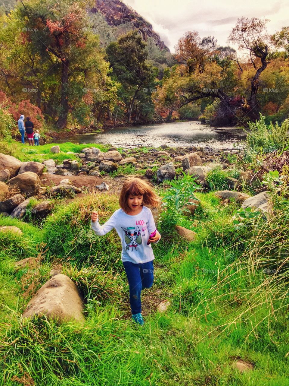 Little girl running with scenic lake in background. Vacaville, CA