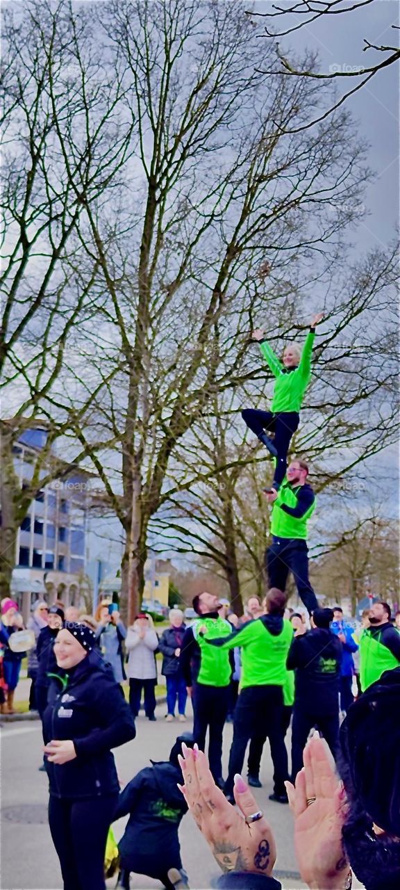 These acrobats form a human tower by carrying men on their shoulders three levels high. It’s part of a carnival parade on “Mardi Gras” or “Fat Tuesday”, last day of the festivities in “Bad Füssing”, “Bavaria”, Germany. 2024. Hypnotic Production