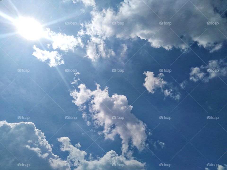 Insects clouds under the sun in the blue sky.