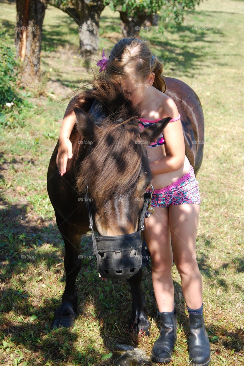 Small girl standing with horse