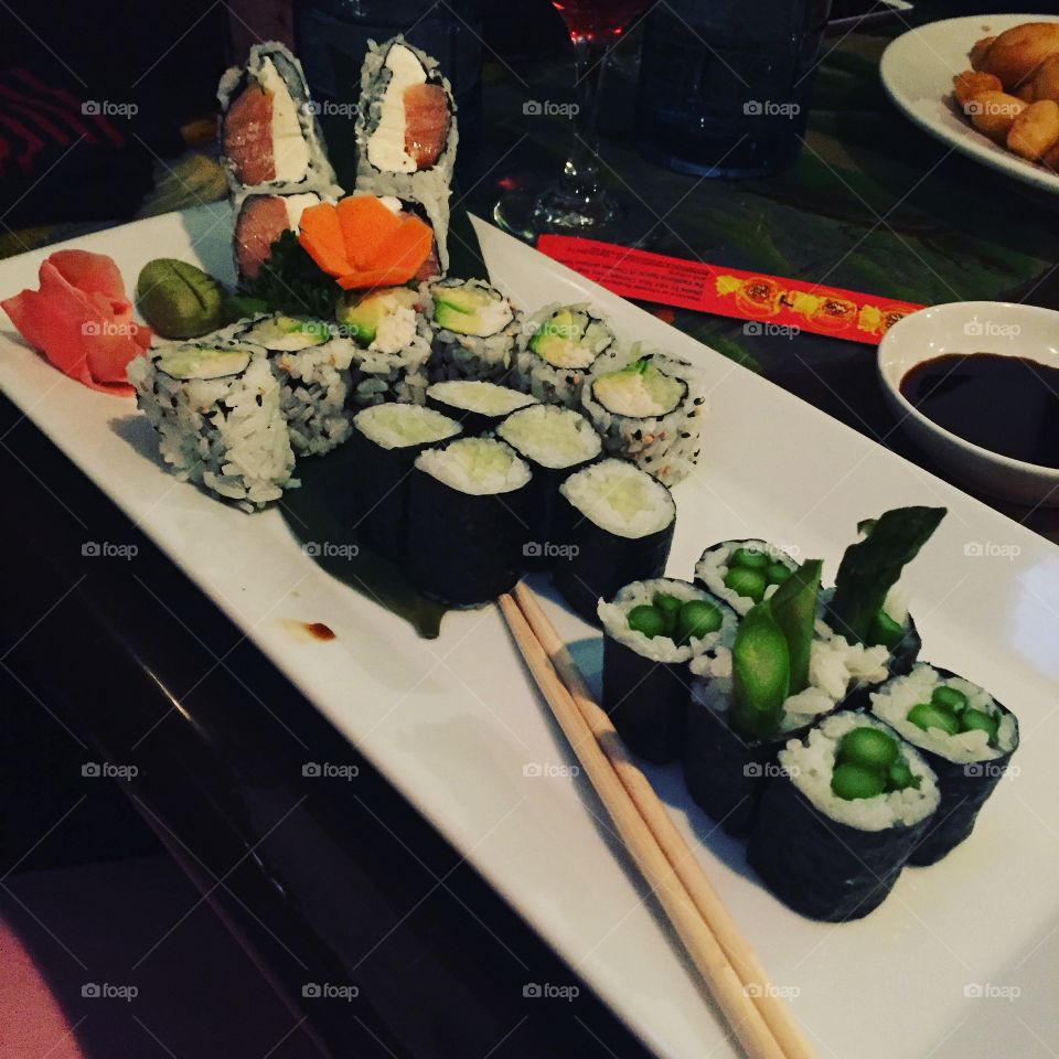 Large plate of colorful sushi with chopsticks