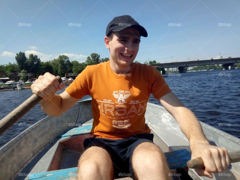 photo moment, portrait of a young dad while sailing a boat on the river with his children