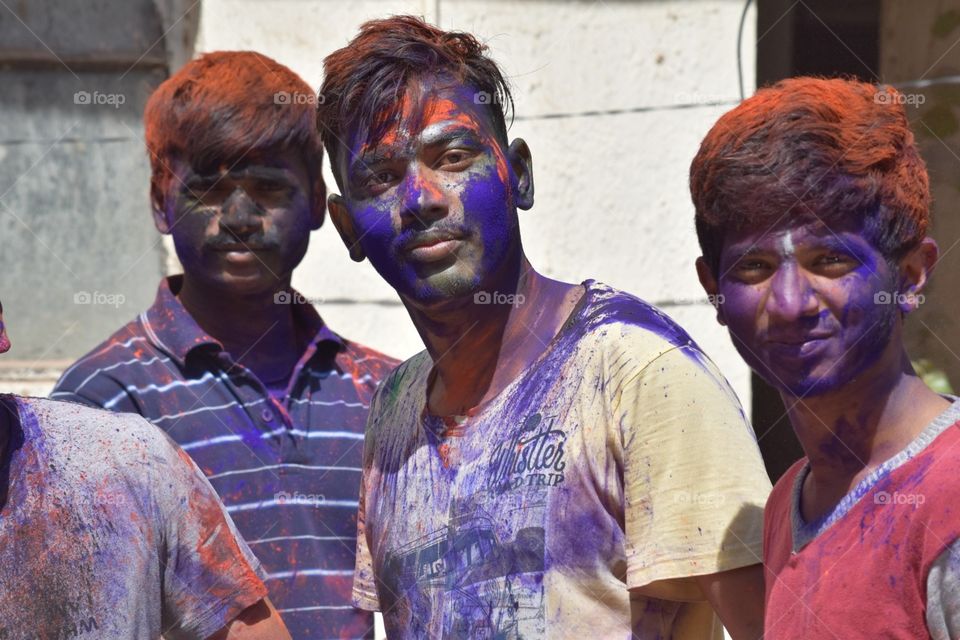 Looking curiously  while celebrating festival of colours