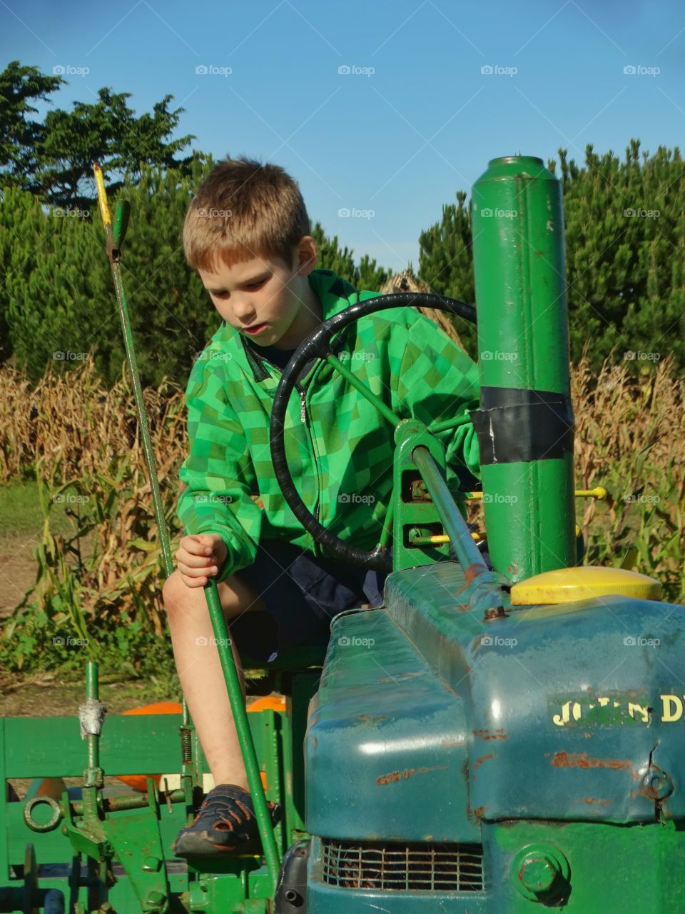 Farm Boy Riding A Tractor
