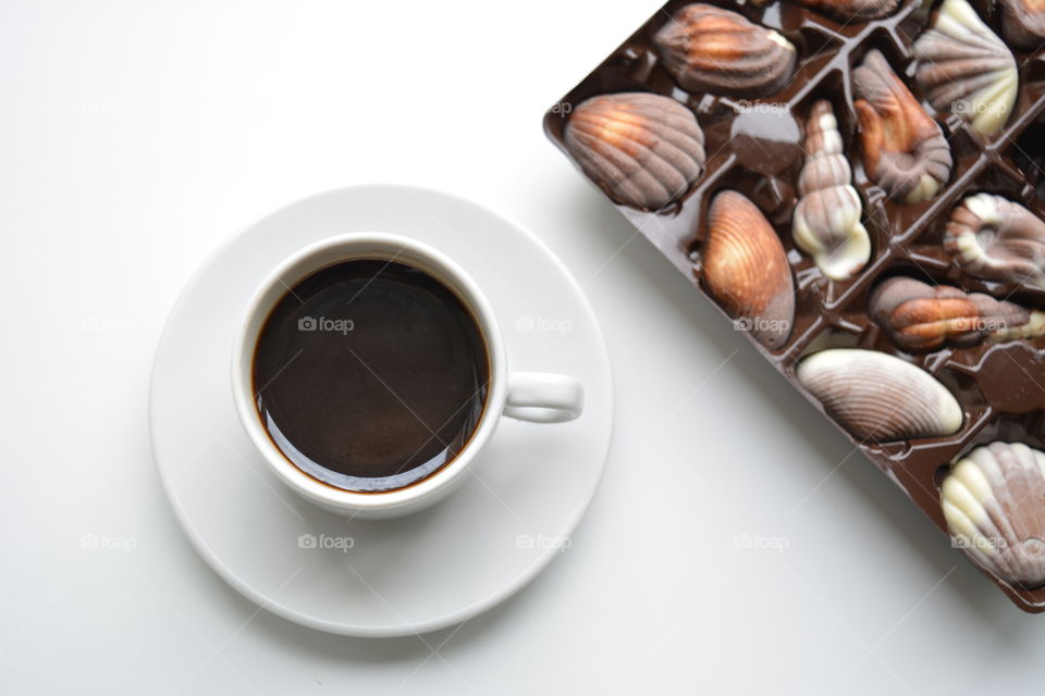 coffee cup with chocolate candy top view on a white background