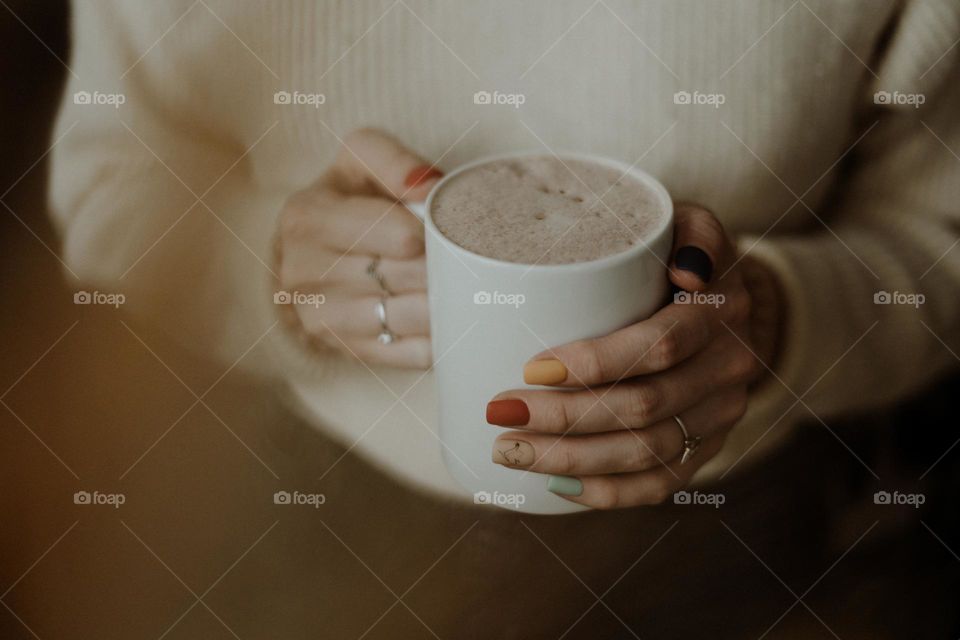 colorful manicure / hands holding hot drink in autumn / autumn foliage / fall colors