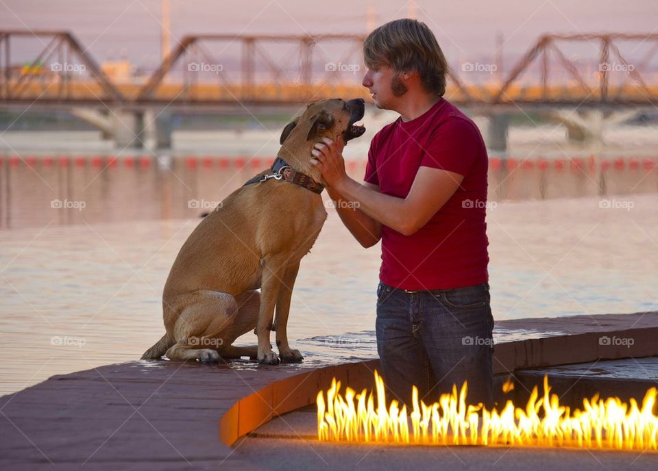 Best friends. A man has a quiet moment with his dog at a lakeside city