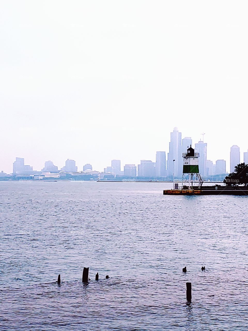 View of foggy downtown Chicago from Lake Michigan with a small lighthouse