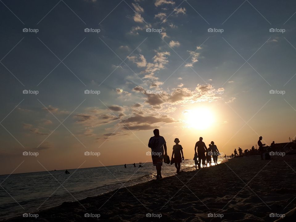 People walking at the sunset beach