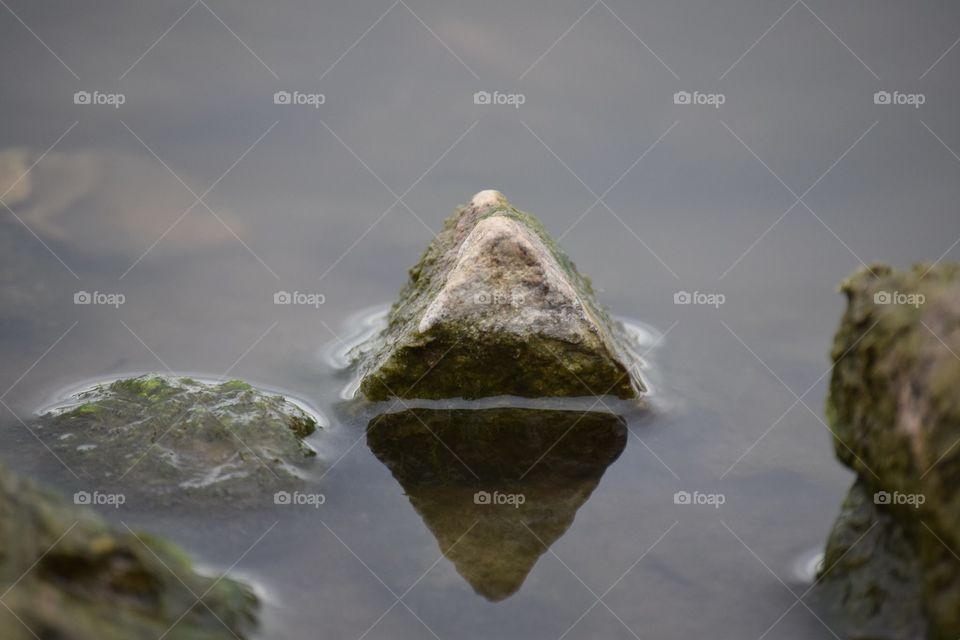 Triangle rock reflected in water 