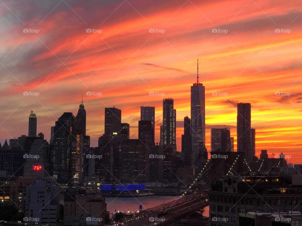 Stunningly Beautiful Orange and Yellow Sunset over the New York Skyline and Bridge, View from DUMBO in Brooklyn