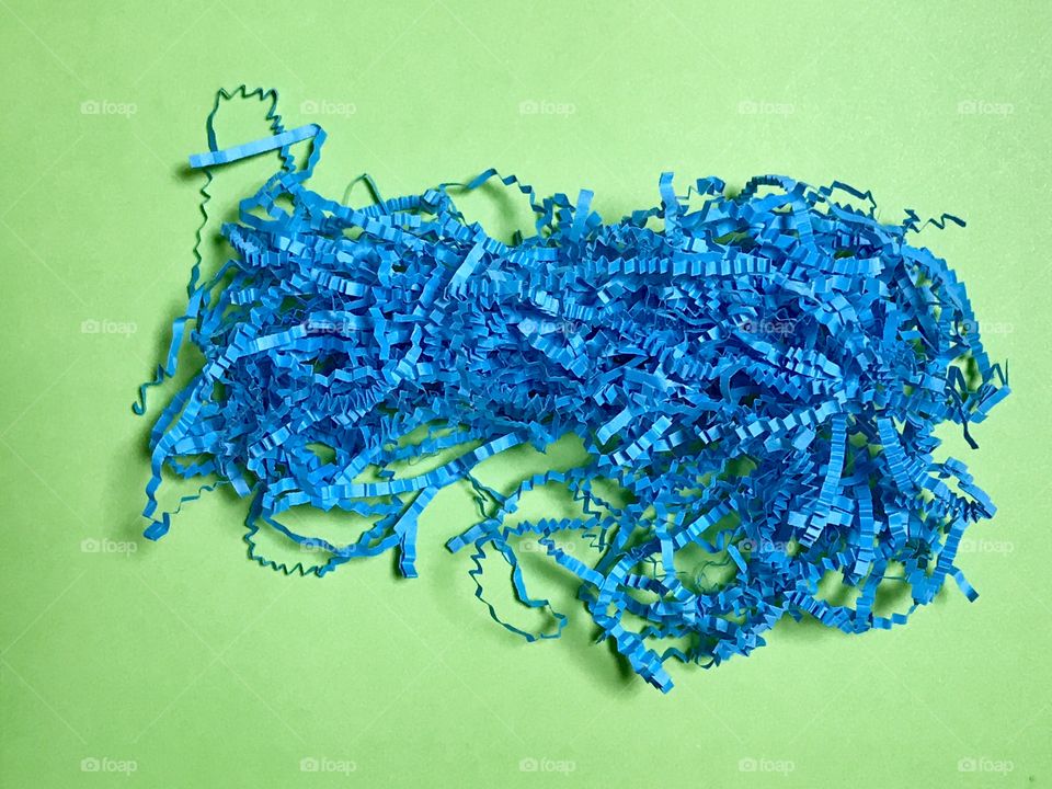 Blue confetti paper on a green background 