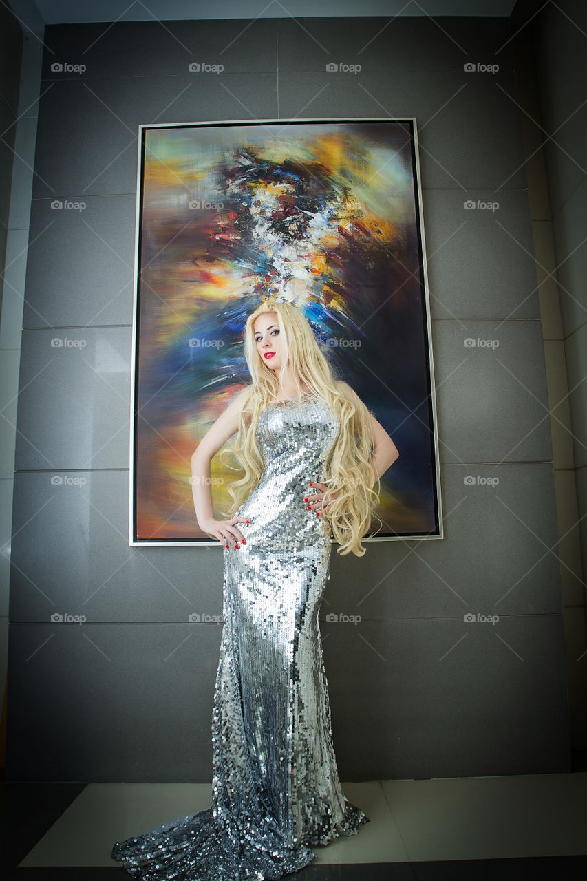 Beautiful famous model wearing a long silver dress 