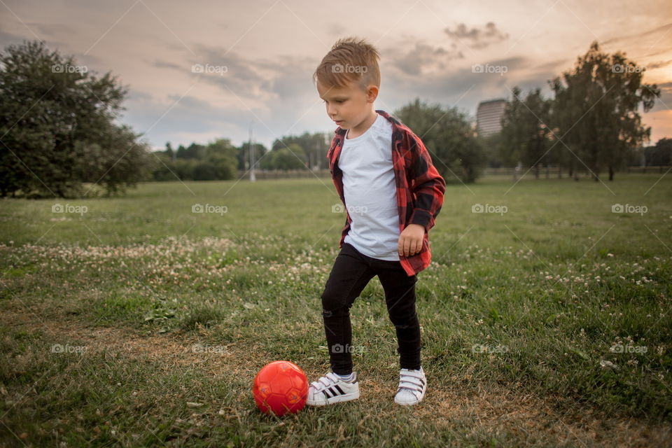 Little boy playing in soccer in a park 