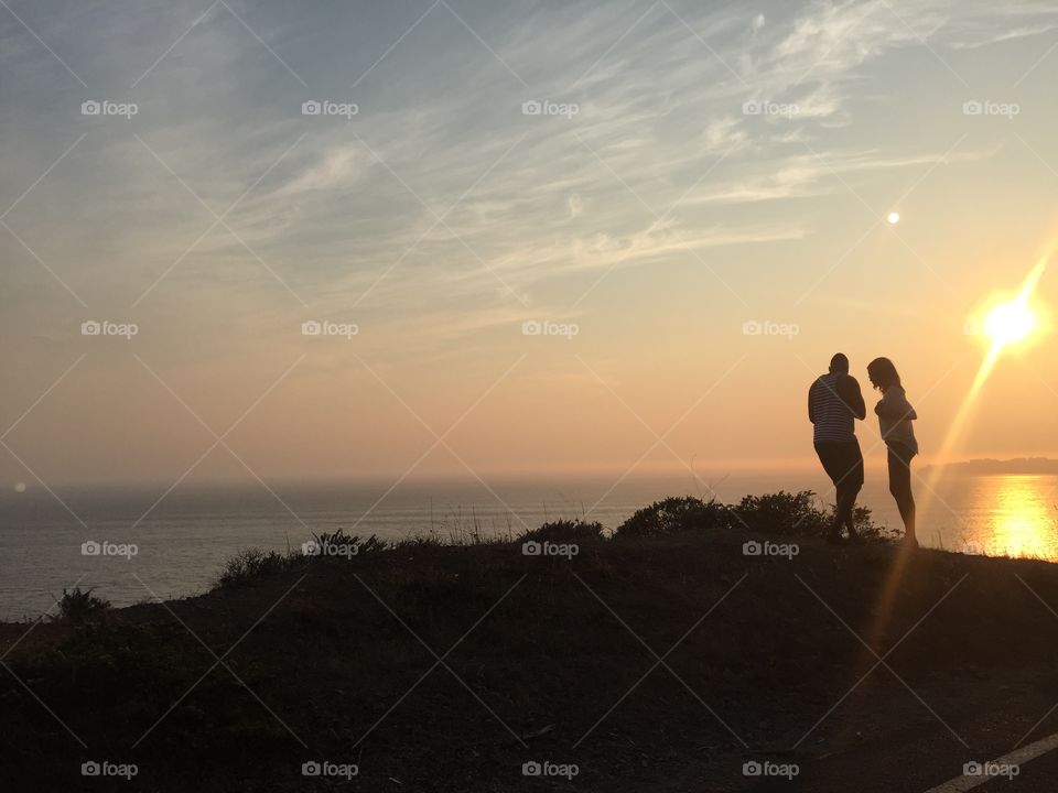 Beach time secrets . A couple exchanges secrets in the sunset 